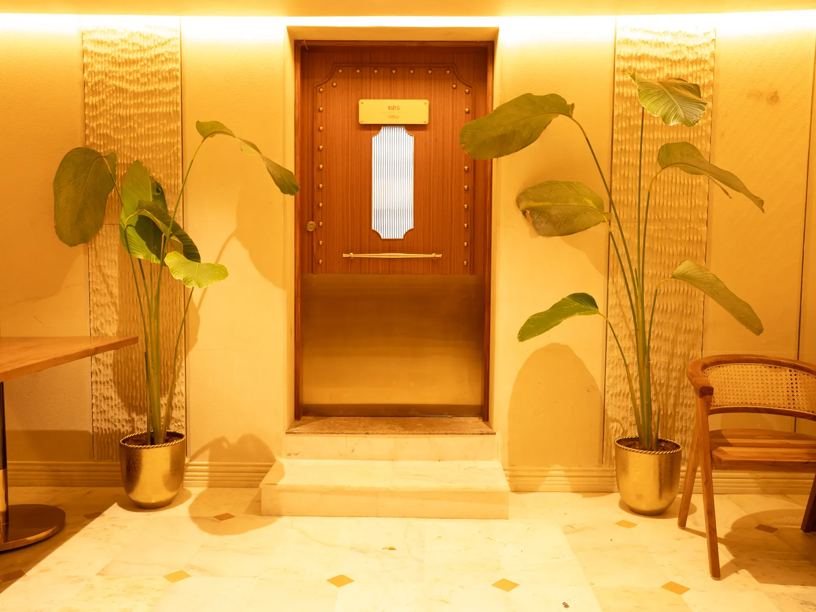 Entrance door flanked by tall planters — Chalukya Samrat